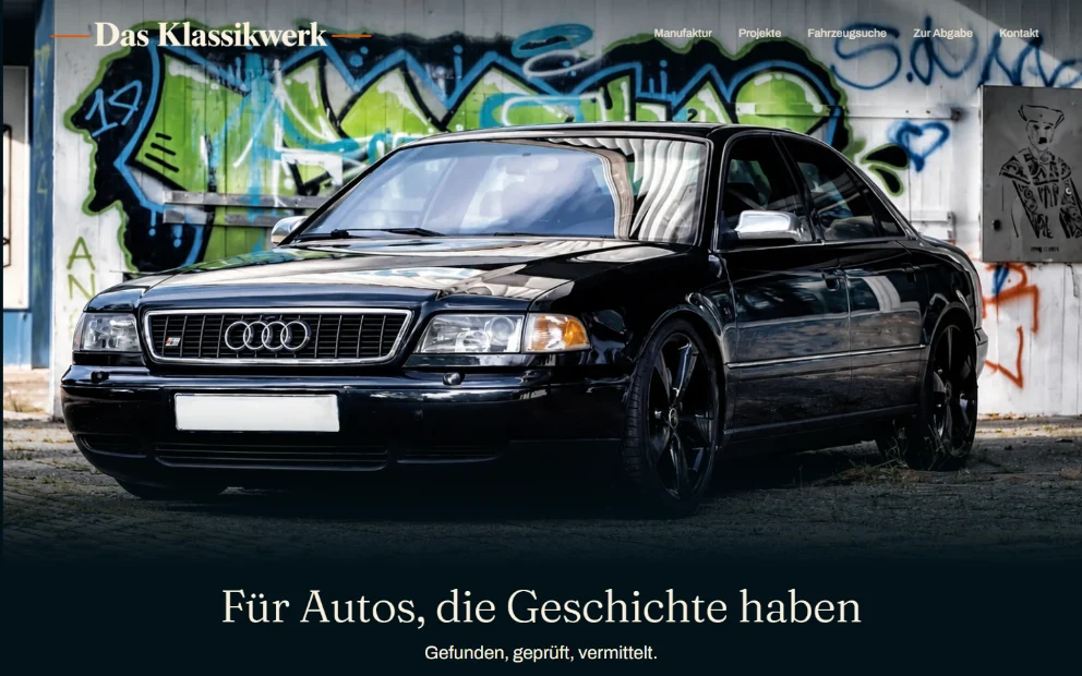 Startseite von dasklassikwerk.de: ein dunkler Audi A8 vor einer Graffiti-Wand, oben links die Wortmarke Das Klassikwerk